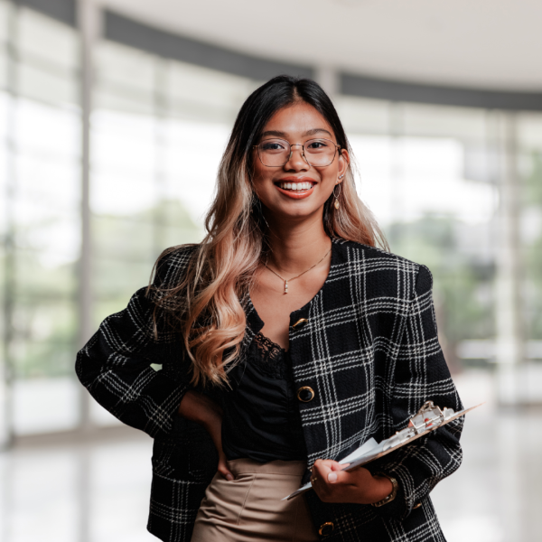 newly qualified solicitor in a law firm office smiling holding a file